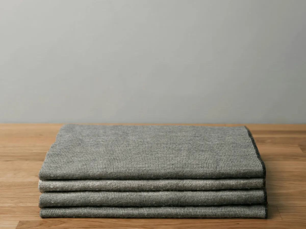 Folded grey towels on a wooden table
