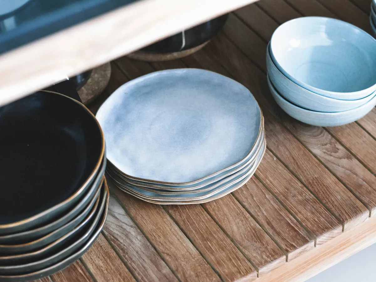 Ceramic plates and bowls on a wooden rack